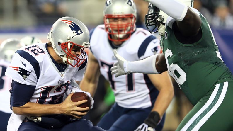 Quarterback Tom Brady of the New England Patriots braces as he is sacked by Muhammad Wilkerson of the New York Jets on Thursday, November 22, at MetLife Stadium in East Rutherford, New Jersey. 