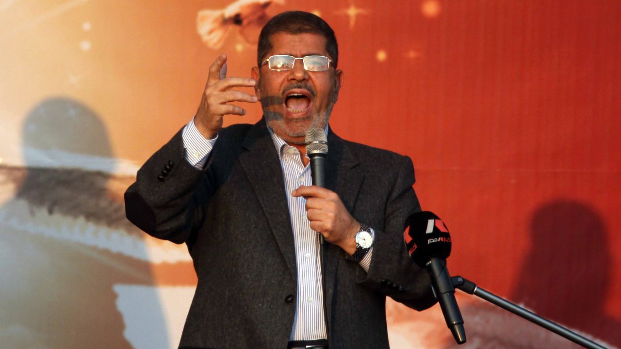President Mohamed Morsy waves to his supporters in front of the presidential palace in Cairo on November 23, 2012.