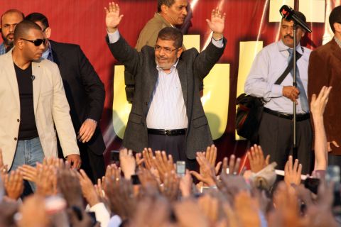 Egyptian President Mohamed Morsy waves to supporters in front of the presidential palace in Cairo on Friday, November 23. Thousands of ecstatic supporters gathered outside the presidential palace to defend their leader against accusations from rival protesters that he has become a dictator. 