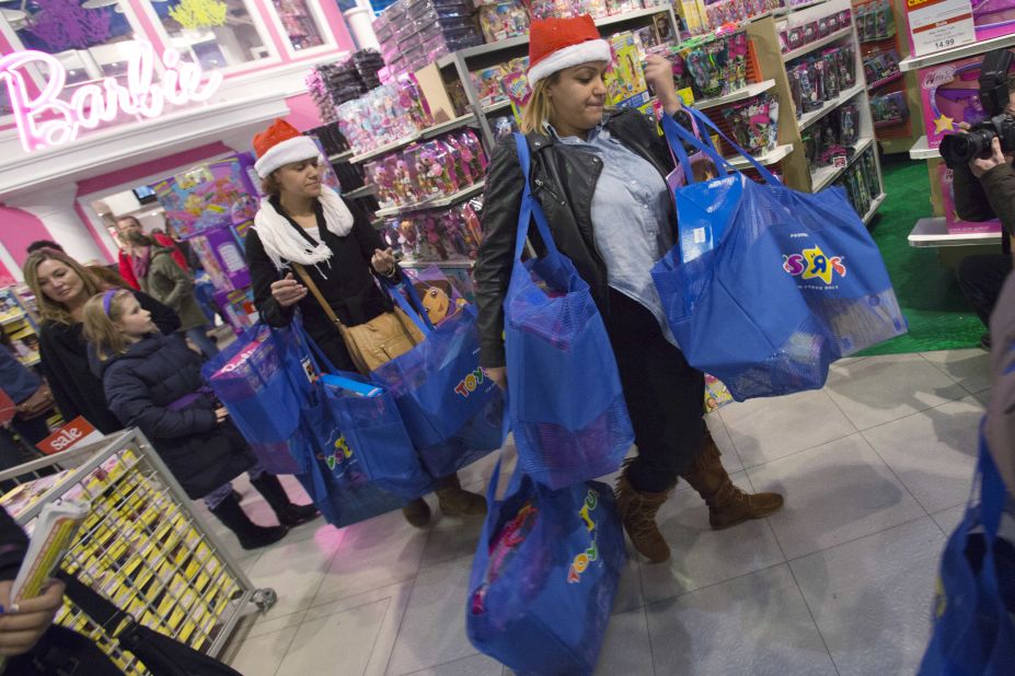 Shoppers leave the Toys R Us holiday sale with bags of goodies.