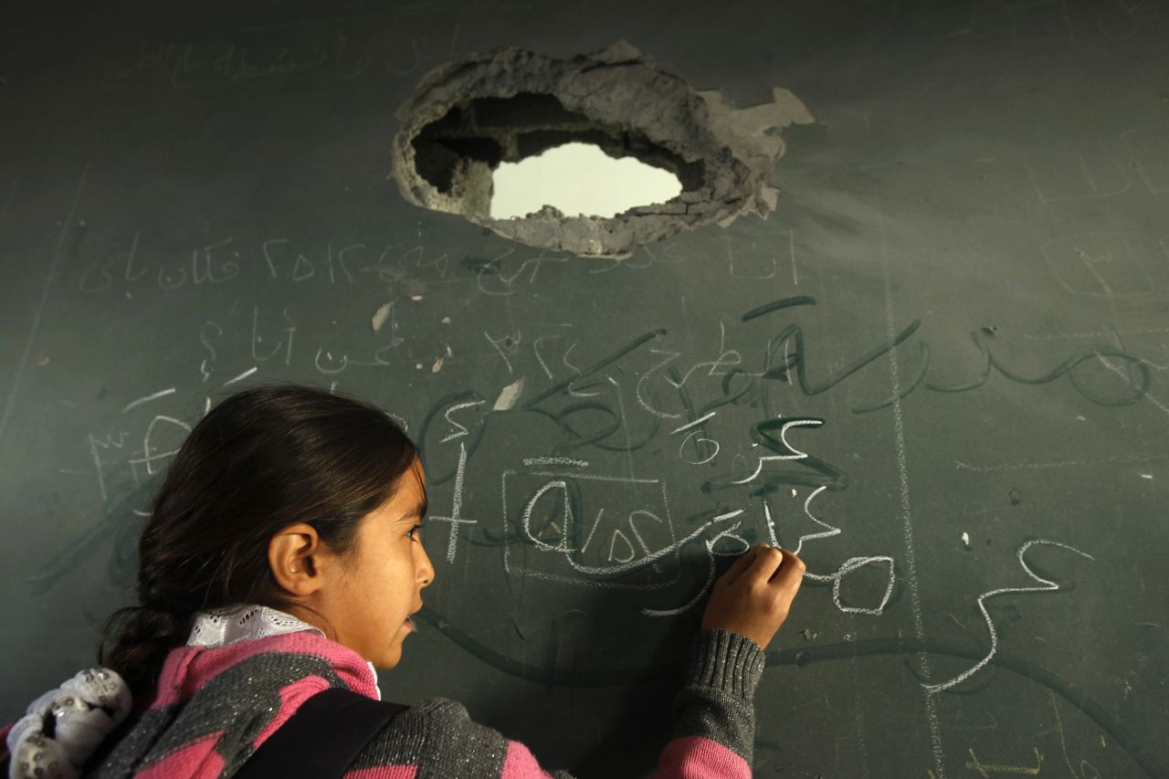 A Palestinian schoolgirl writes on the blackboard of a classroom in Gaza City on Saturday.