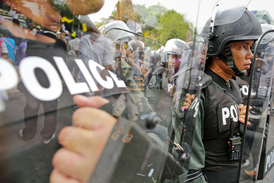 Riot police shield themselves from protesters on Saturday.