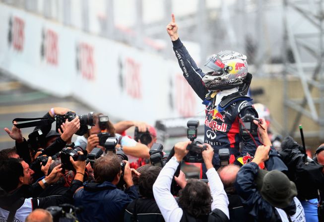 Sebastian Vettel celebrates after securing his third consecutive Formula One title. The Red Bull racer claimed a sixth place finish at the Brazilian Grand Prix to win the championship by three points from Fernando Alonso.