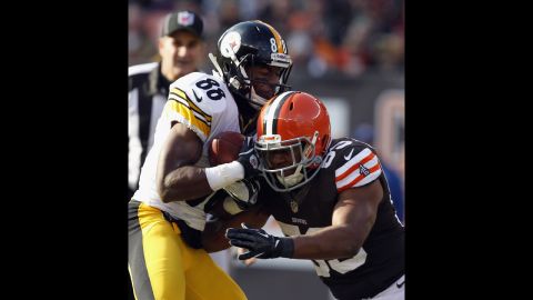 Wide receiver Emmanuel Sanders of the Steelers is hit by linebacker Craig Robertson of the Browns on Sunday.