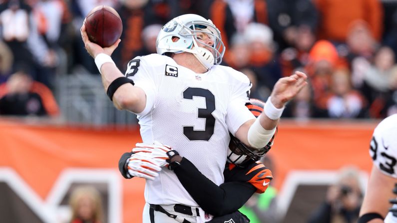Carson Palmer of the Oakland Raiders is hit by Reggie Nelson of the Cincinnati Bengals as he throws a pass at Paul Brown Stadium on Sunday in Cincinnati.