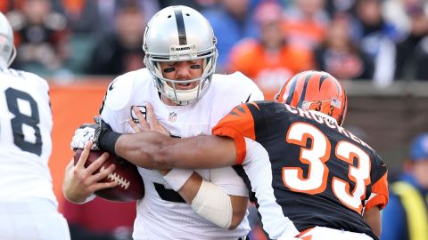 Carson Palmer of the Raiders is hit by Chris Crocker of the Bengals on Sunday.