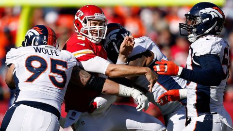 Quarterback Brady Quinn of the Chiefs is hit by defensive end Derek Wolfe of the Broncos just after releasing the ball on Sunday.