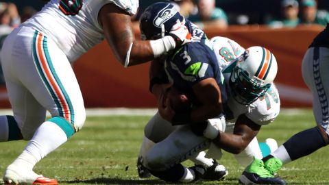 Quarterback Russell Wilson of the Seahawks is sacked by Tony McDaniel of the Dolphins on Sunday.