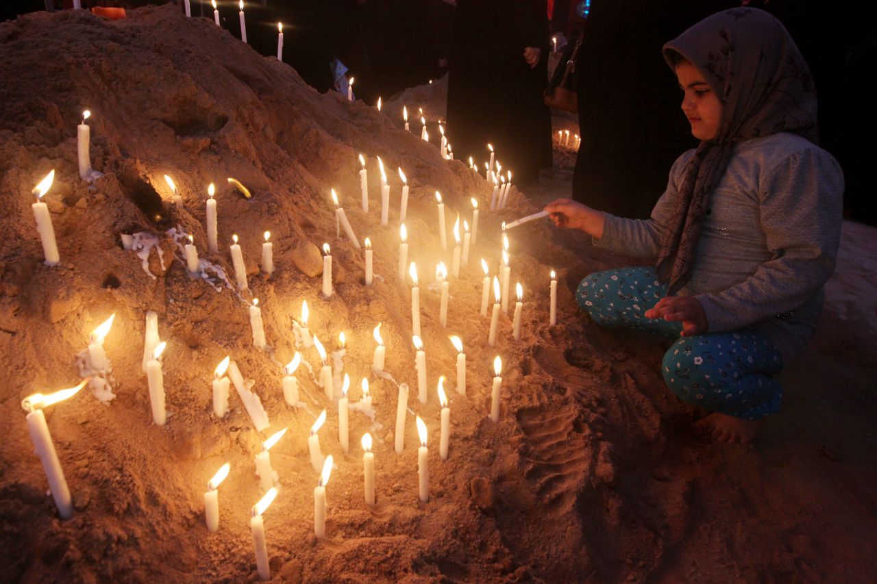A girl lights a candle next to the Imam Hussein shrine as part of the ritual ceremony of Ashura in Karbala, Iraq, on November 25, 2012. 