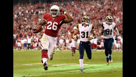 Running back Beanie Wells of the Cardinals carries the football 12 yards into the end zone past cornerback Cortland Finnegan of the Rams during the second quarter on Sunday.