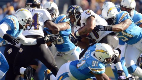 Ray Rice of the Ravens is tackled by Takeo Spikes and Kendall Reyes of the Chargers for a stop on third down on Sunday.