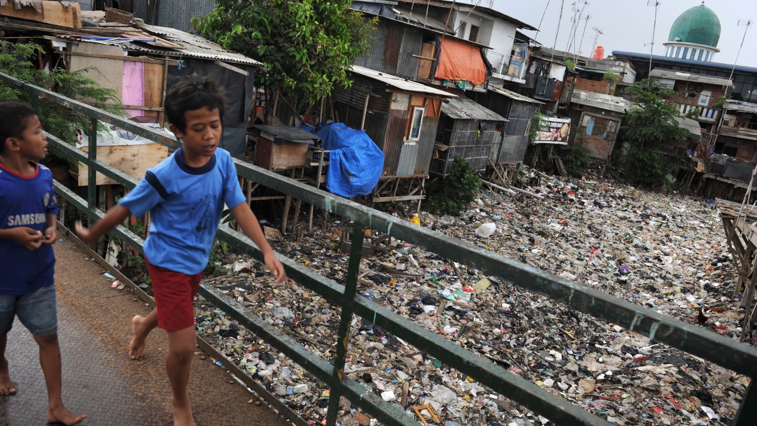 (File photo) Children walk on a footbridge over the polluted Cipinang river in Jakarta on November 13, 2012