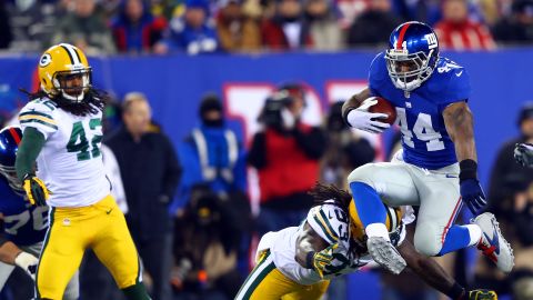 Ahmad Bradshaw of the New York Giants jumps over the attempted tackle of outside linebacker Erik Walden of the Green Bay Packers on Sunday, November 25, at MetLife Stadium in East Rutherford, New Jersey.