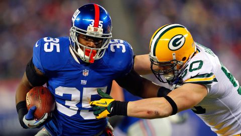 Andre Brown of the New York Giants tries to break a tackle by A.J. Hawk of the Green Bay Packers.