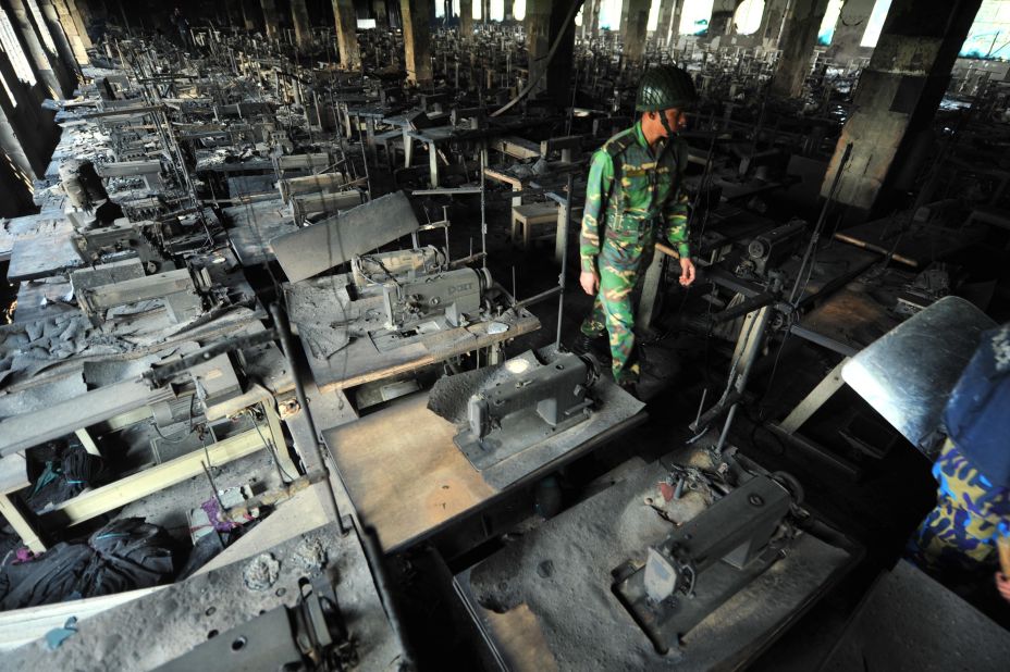 A Bangladeshi army staffer walks through rows of charred sewing machines on November 25.