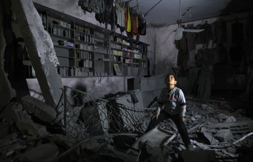 A boy stands in the rubble of a destroyed shop in Beit Lahia, in northern Gaza, on Monday, November 26.