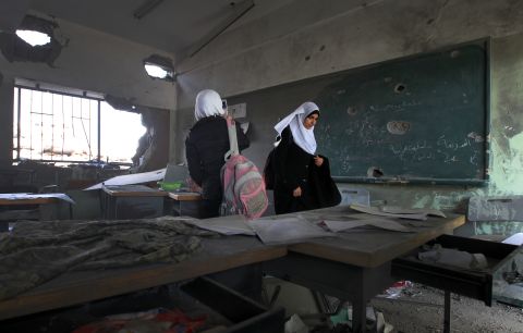 Palestinian school girls walk in a destroyed class room on Monday, November 26, in Gaza. The school was damaged some days ago, before a truce between Hamas and Israel.
