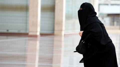 A fully veiled Saudi woman walks into a mall in Riyadh. Women's "guardians" are notified whenever one leaves the country.