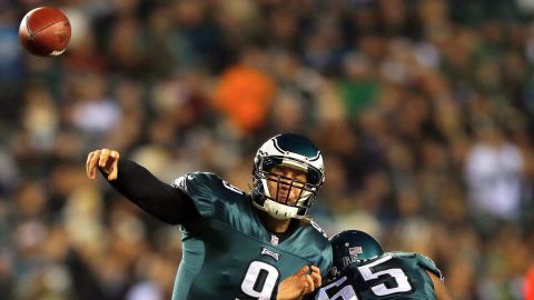 Eagles quarterback Nick Foles passes the ball as teammate King Dunlap blocks in the first quarter against the Carolina Panthers.