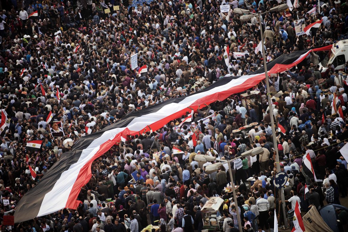 Egyptians carry a giant national flag as tens of thousands take part in a mass rally in Cairo on Tuesday, November 27, against a decree by President Mohamed Morsy granting himself broad powers. 