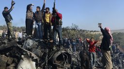 Syrian rebels celebrate on top of the remains of a Syrian government fighter jet which was shot down at Daret Ezza, on November 28, 2012.