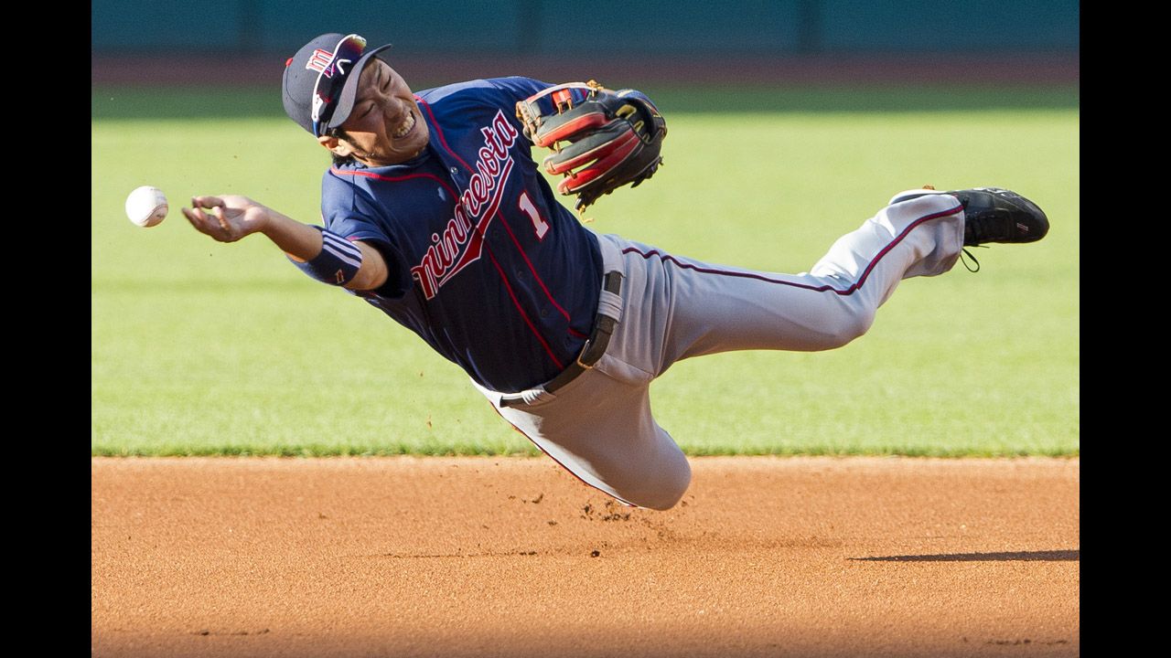 Second baseman Tsuyoshi Nishioka of the Minnesota Twins attempts to make a throw to first base during a game against the Cleveland Indians on August 6 in Cleveland, Ohio.