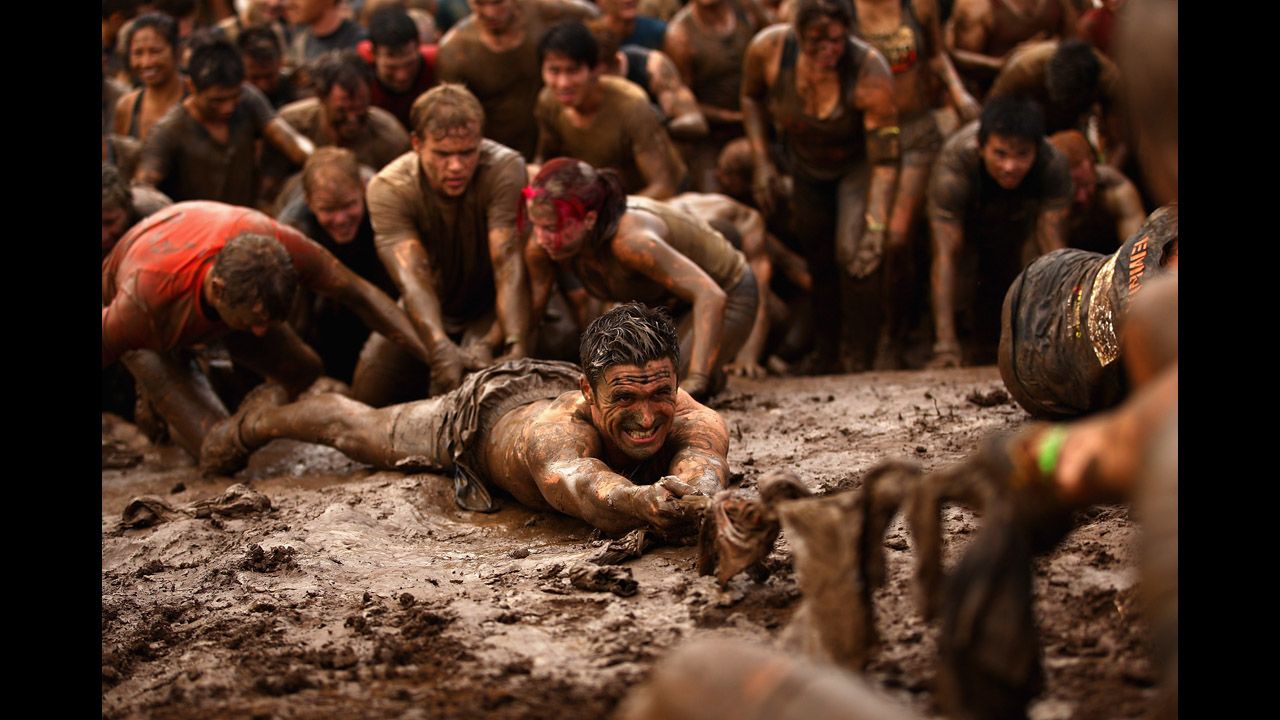 Competitors help pull each other up a mud hill during the 2012 Tough Mudder on April 1 in Phillip Island,  Australia.