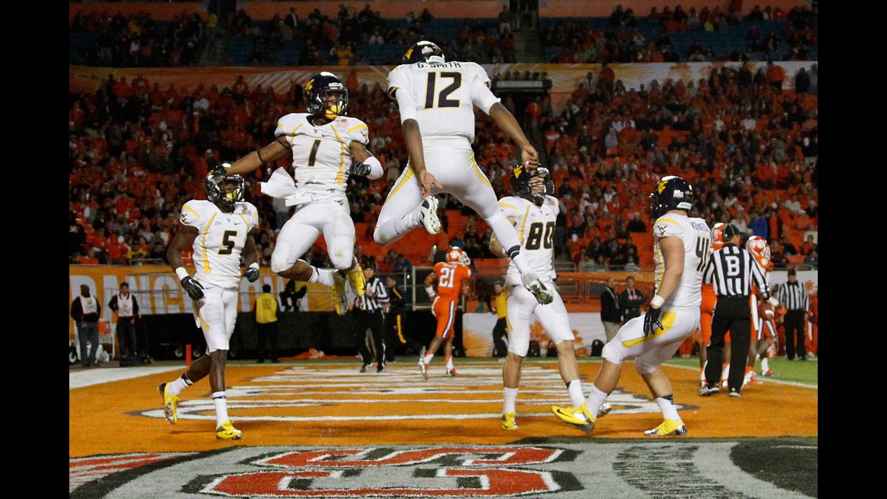 No. 1 Tavon Austin and No. 12 Geno Smith of the West Virginia Mountaineers celebrate after Austin caught a 37-yard touchdown reception thrown by Smith in the third quarter against the Clemson Tigers during the Discover Orange Bowl on January 4 in Miami Gardens, Florida. The Mountaineers won 70-33.