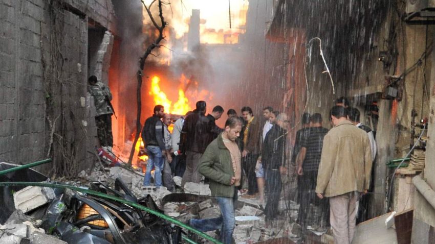 Syrian men inspect the scene of a car bomb explosion in Jaramana, a suburb of Damascus, on November 28, 2012.