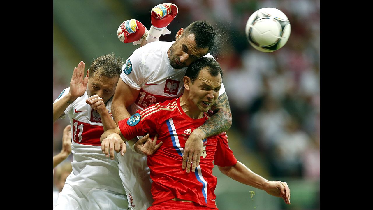 From left, Rafal Murawski and Marcin Wasilewski of Poland vie for the ball with Sergei Ignashevich of Russia during the Group A preliminary round match of the UEFA EURO 2012 between Poland and Russia in Warsaw, Poland, on June 12.