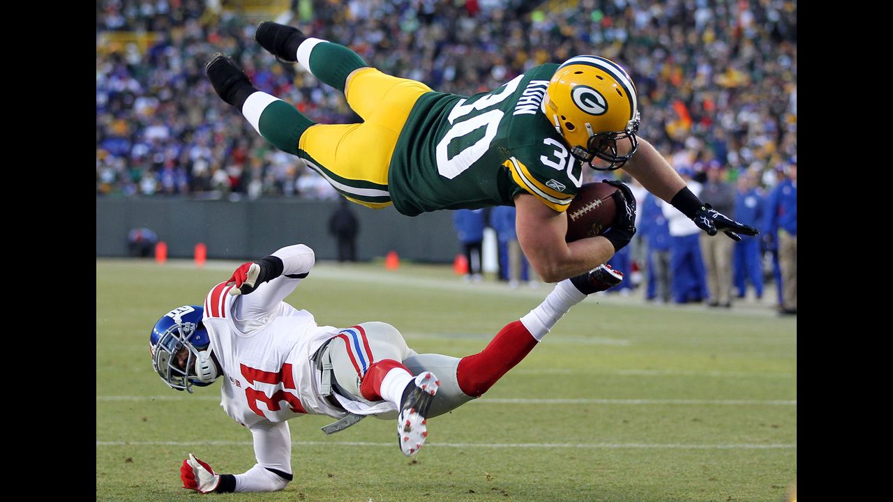 John Kuhn of the Green Bay Packers dives in for the touchdown over Aaron Ross of the New York Giants during their NFC divisional playoff game on January 15 at Lambeau Field in Green Bay, Wisconsin. 