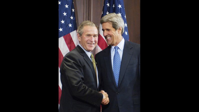 President George W. Bush shakes hands with 2004 rival Sen. John Kerry, D-Massachusetts, a year after the election at a ceremony for Bush to sign a bill that Kerry co-sponsored.