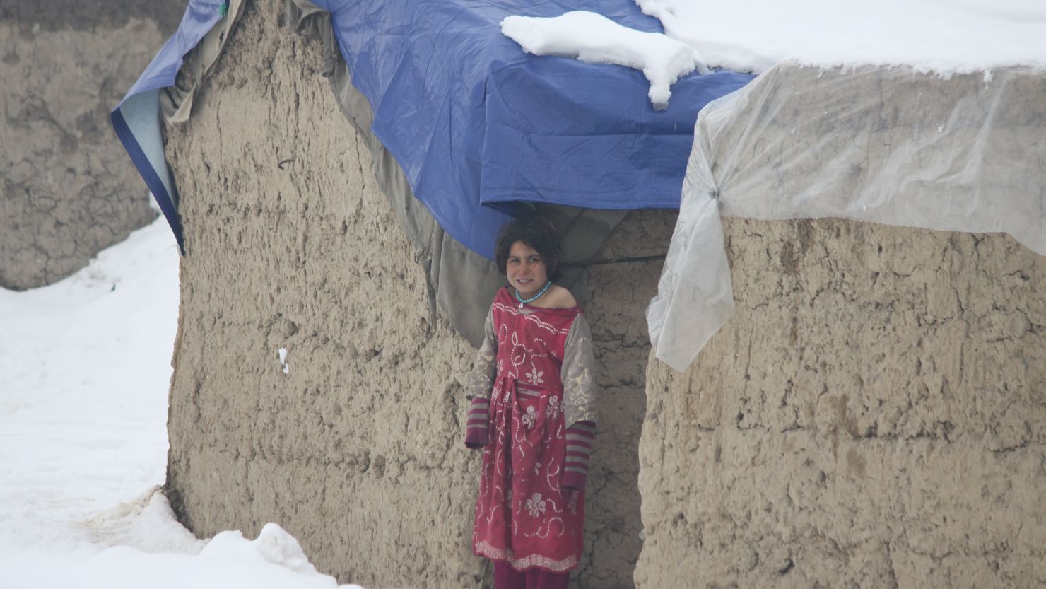 A child refugee shivers in the cold weather in a makeshift home in the eastern part of Kabul, Afghanistan.