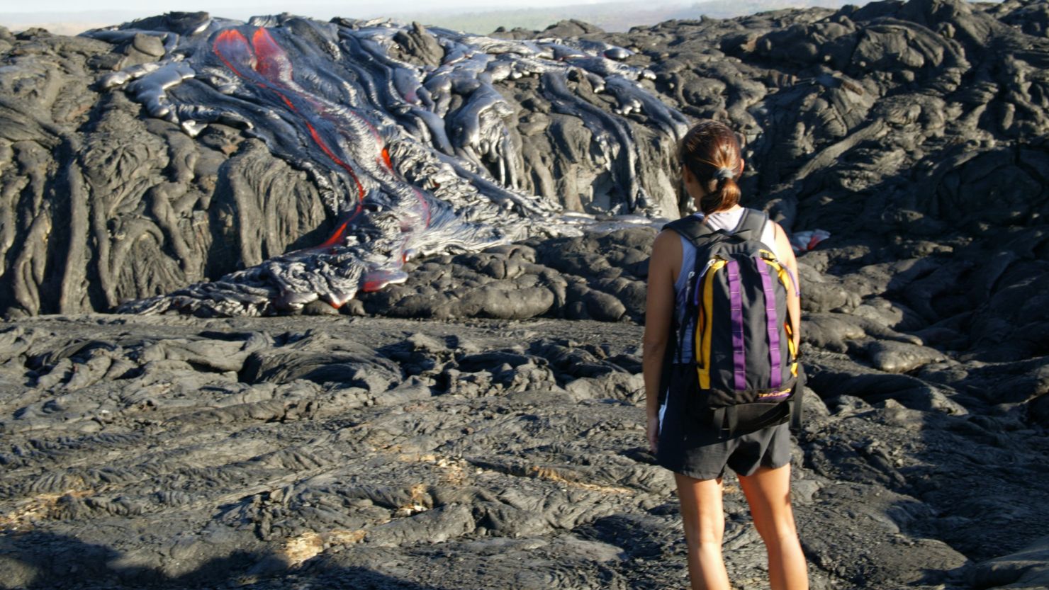 VOLCANO NATIONAL PARK HAWAII: Hiker Gigi Galong, of Kona, watches the lava flow in Volcano National Park.