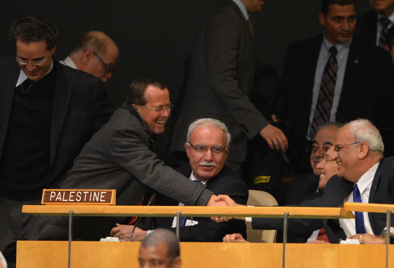 Palestinian delegates are greeted by delegates from other member countries before the vote.