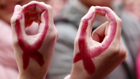 Chinese students show their hands painted to look like red ribbons during a World AIDS Day event on November 30. 
