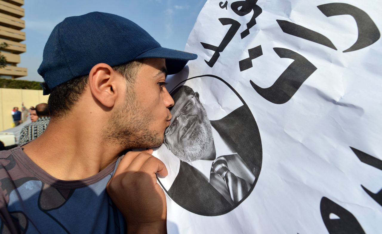 A man kisses a portrait of Morsy during a gathering of thousands of Islamists in front of Cairo University on Saturday, December 1.