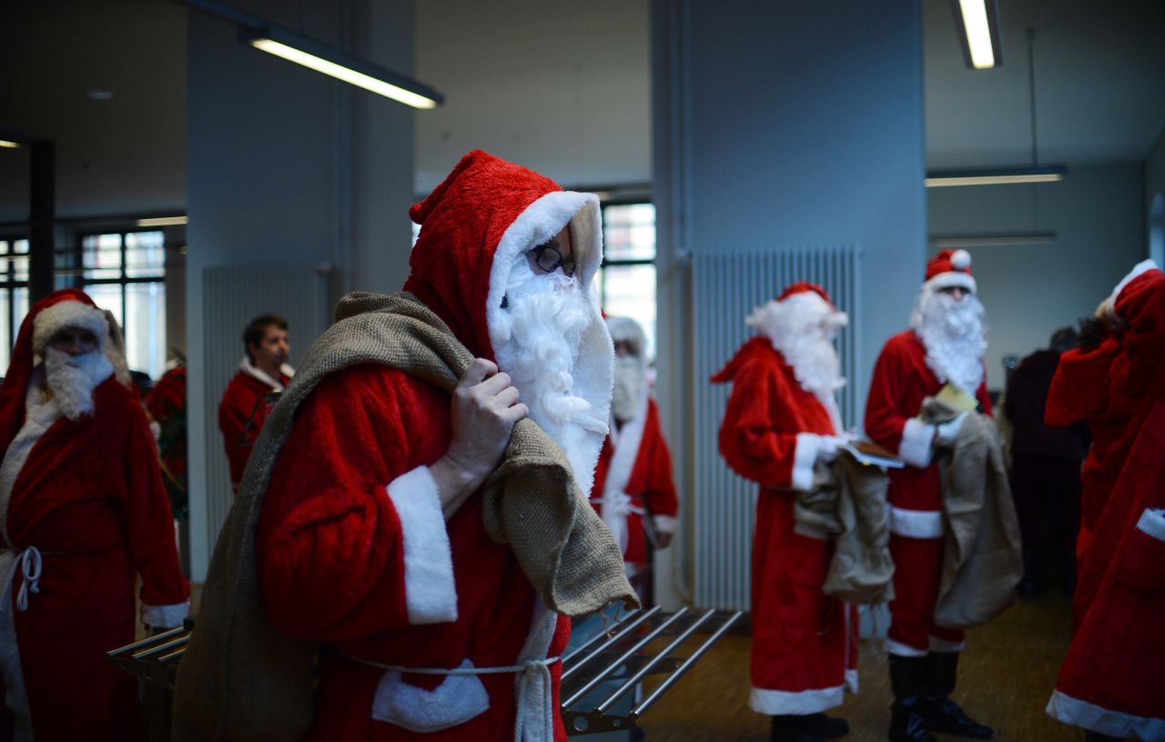 Men dressed as Santa Claus carry sacks through the meeting of volunteer Santa Clauses and angels on December 1 in Berlin.
