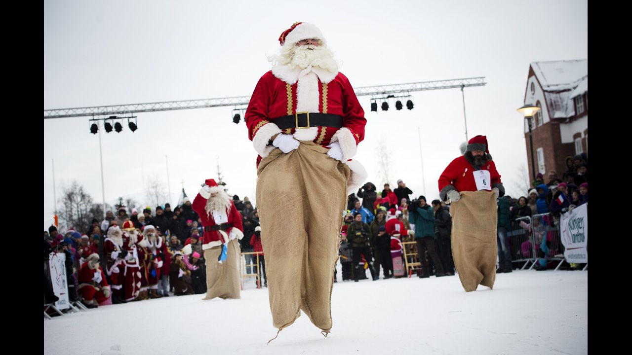 Estonian Santa Claus "Santa Aare," from left, Dutch Santa Claus "Santa Holland" and Swedish Santa Claus "Snaretomten" compete in the Kicksled Sack Race during the Santa Claus Winter Games in Gallivare, Sweden, on Saturday, November 17. Santas from around the world gathered to participate in Christmas-themed competitions that weekend.