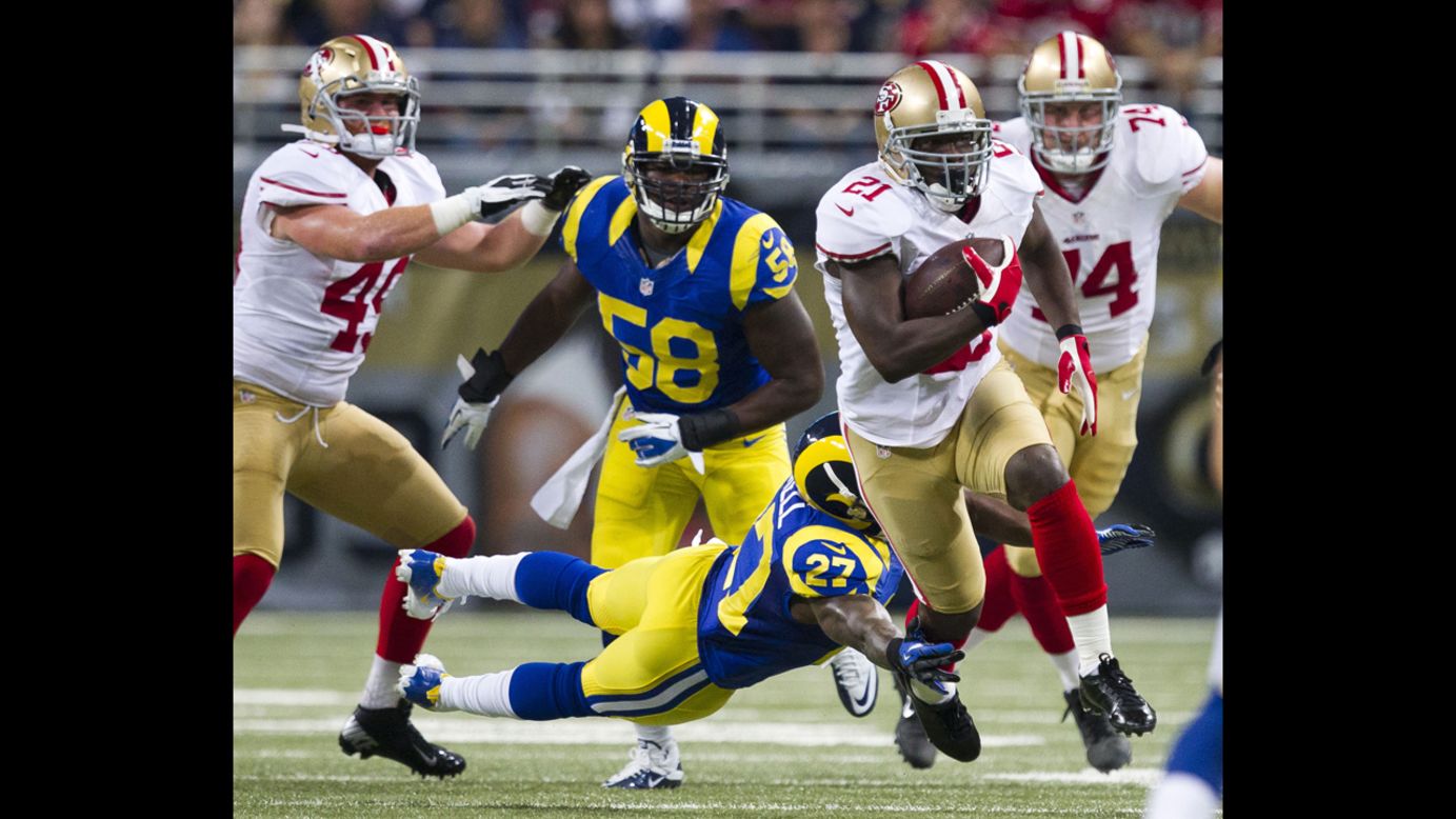 Running back Frank Gore of the San Francisco 49ers evades Quintin Mikell of the St. Louis Rams on Sunday.