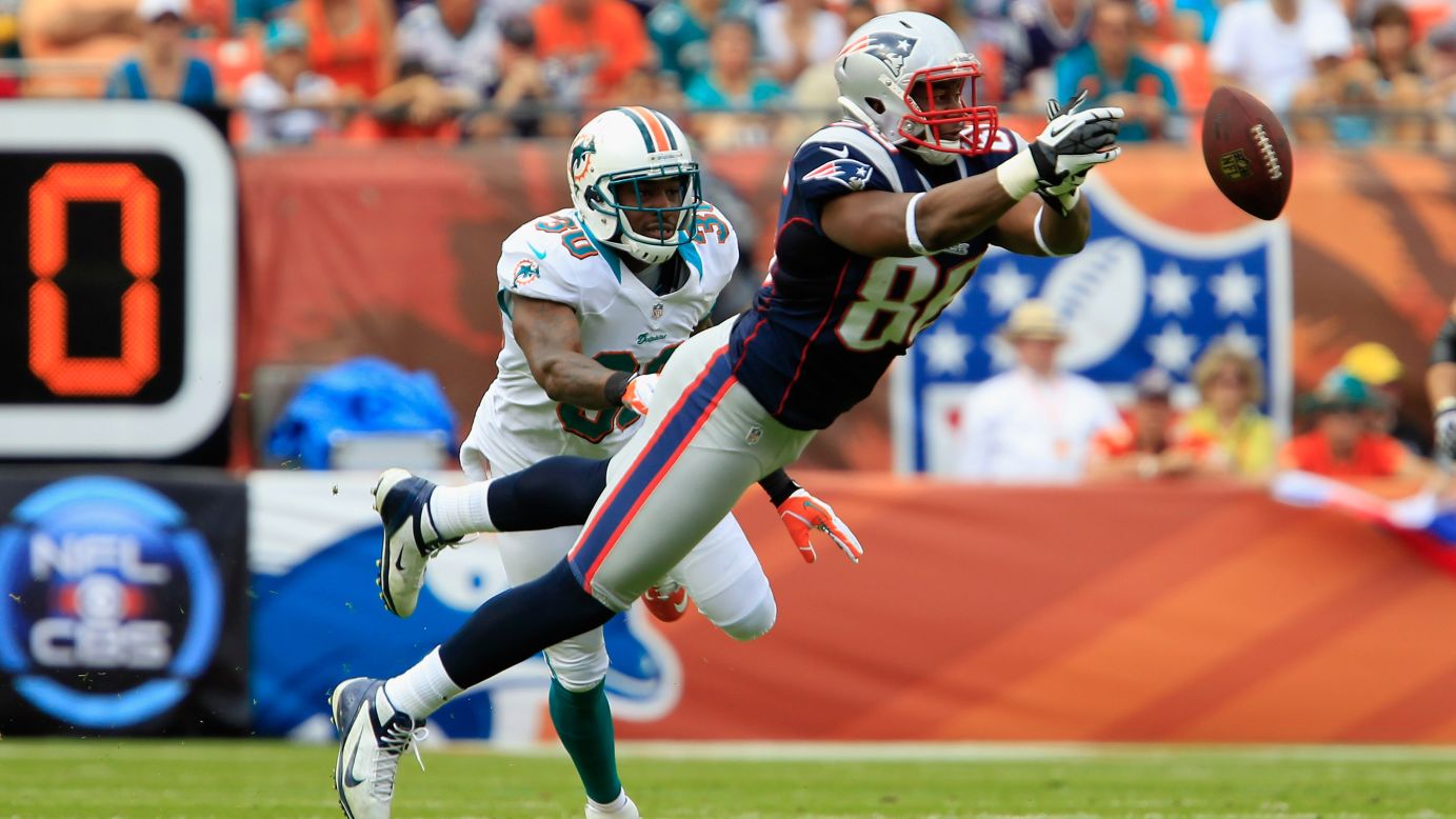 Tight end Daniel Fells of the New England Patriots misses a catch as strong safety Chris Clemons of the Miami Dolphins looks on Sunday.