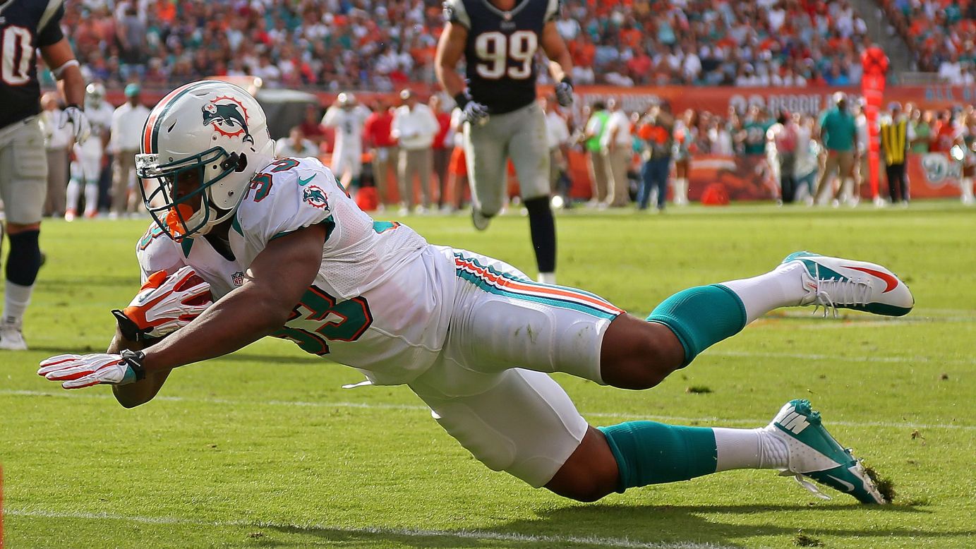 Daniel Thomas of the Miami Dolphins falls during the game against the New England Patriots on Sunday.