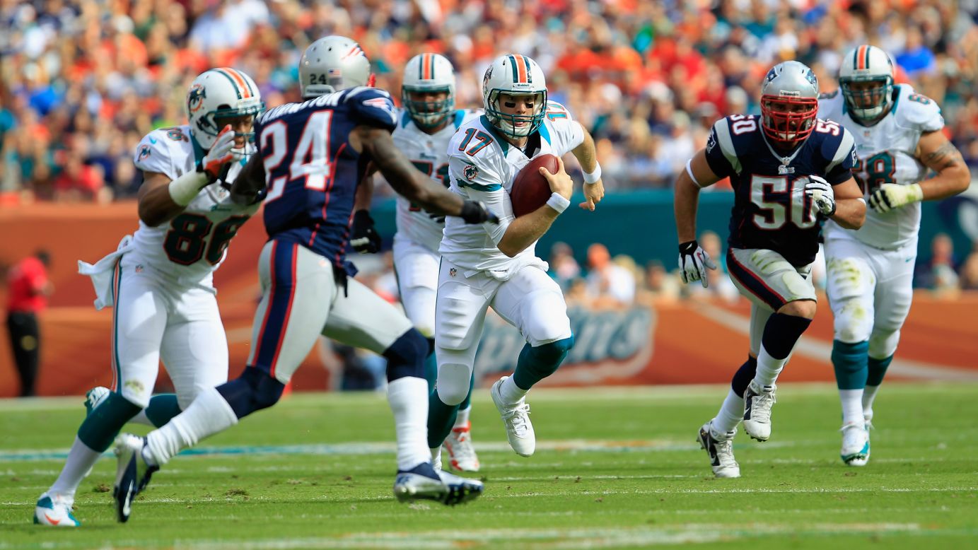 Quarterback Ryan Tannehill of the Miami Dolphins runs the ball against cornerback Kyle Arrington of the New England Patriots on Sunday.