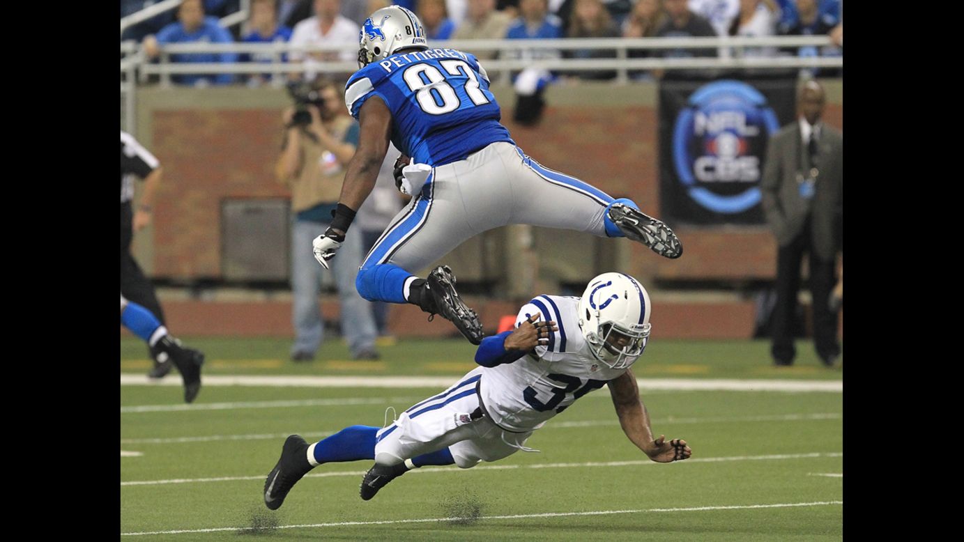 Brandon Pettigrew of the Detroit Lions leaps over the attempted tackle of Joe Lefeged of the Indianapolis Colts on Sunday.