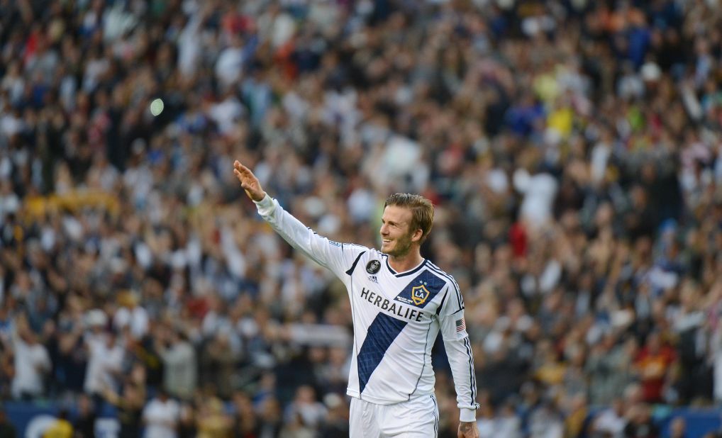 Beckham waves to fans as he walks off the pitch after the game.