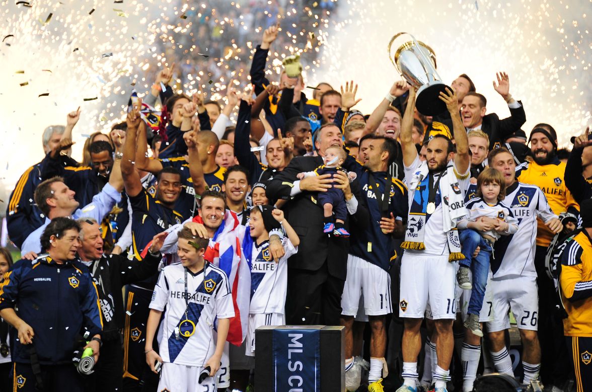 Galaxy captain Landon Donovan holds up the MLS Trophy as David Beckham, lower left, and other teammates celebrate their win.