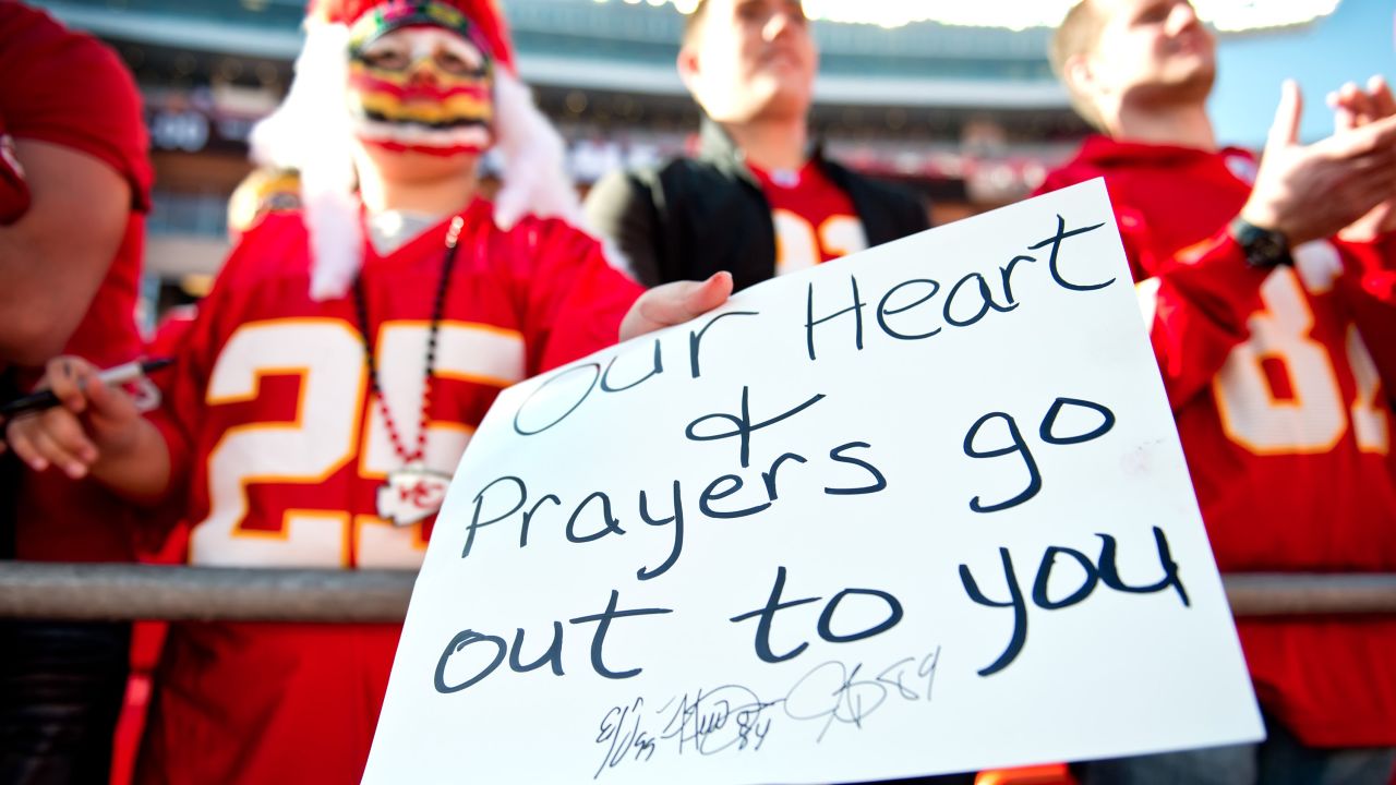 A young fan holds a condolences sign for the Kansas City Chiefs prior to the team's game against the Carolina Panthers.