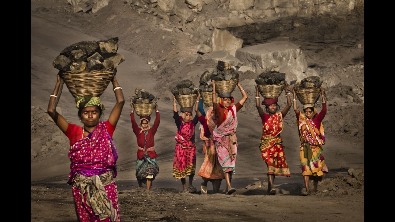 <strong>February 11: </strong>Villagers carry coal scavenged illegally from an open-cast coal mine in the village of Jina Gora, India. Claiming that a decades-old underground coal fire threatened the homes of villagers, the government relocated more than 2,300 families.