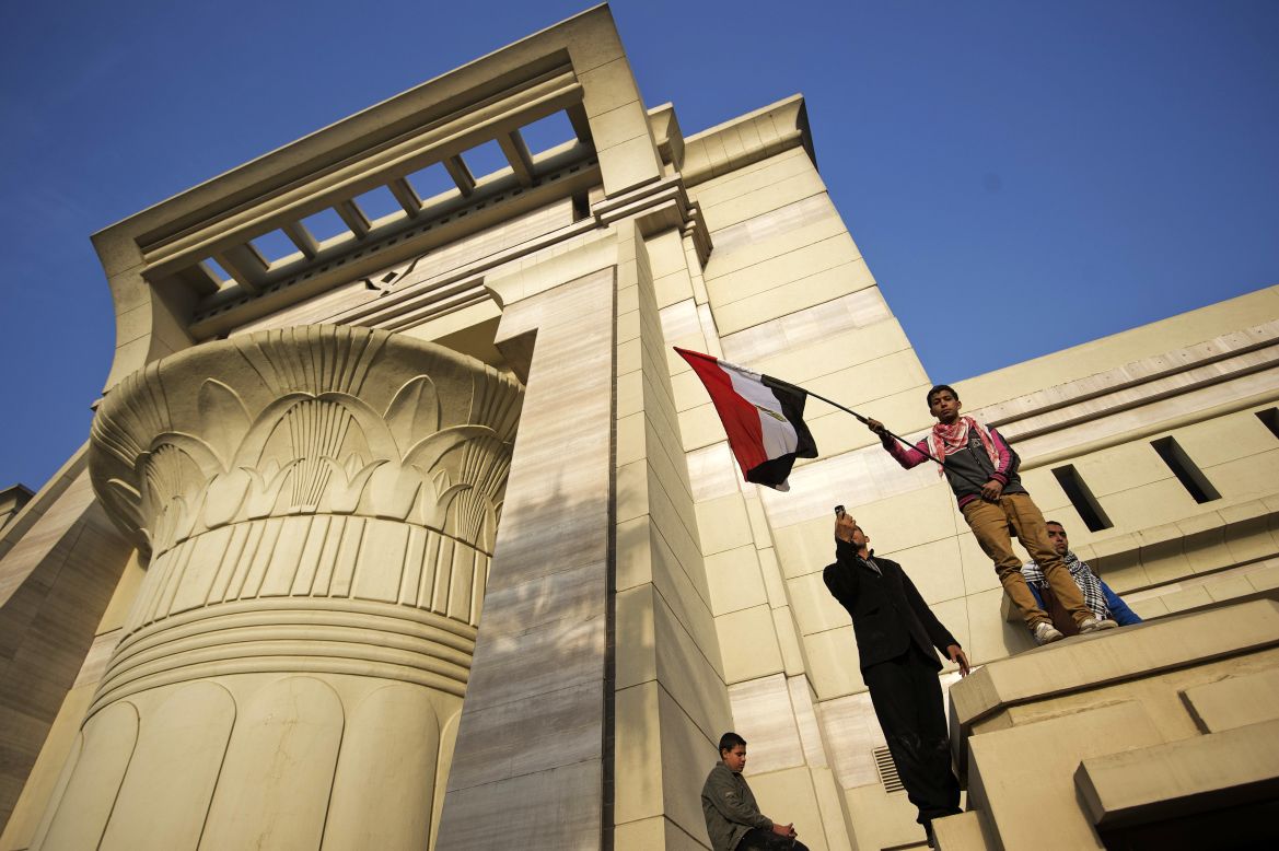 A Morsy supporter waves a flag outside the Supreme Constitutional Court as hundreds of supporters of the president protest on Sunday, December 2, in Cairo, forcing judges to postpone a hearing on a constitutional panel at the heart of a deepening political crisis.