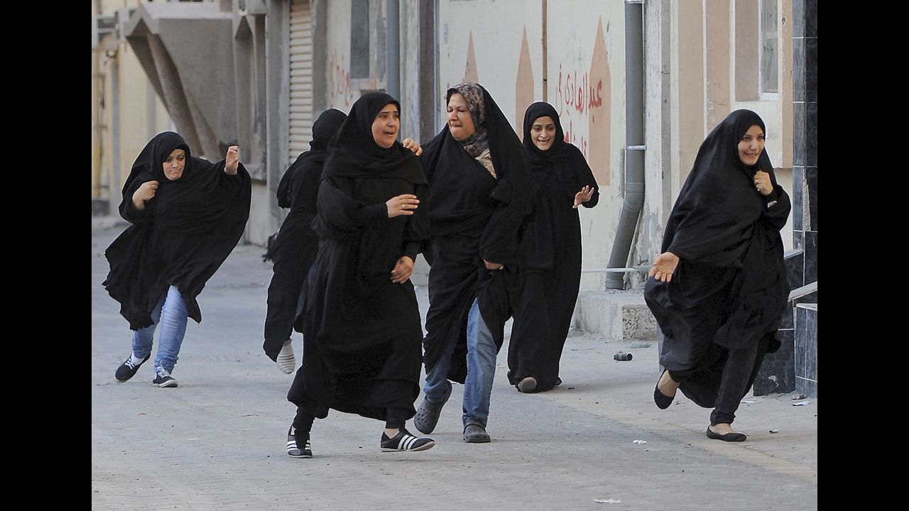 <strong>June 27: </strong>Protesters run for cover as police arrive to disperse a rally demanding human rights reforms in the village of Buri, south of Bahrain's capital, Manama. A court in Bahrain sentenced prominent activist Nabeel Rajab to three years in prison in August "for participating in illegal rallies and gatherings."